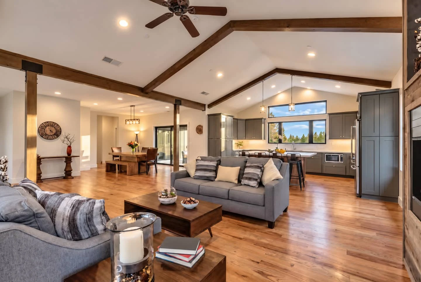 Spacious living room with sofas, wood floors and a forest view